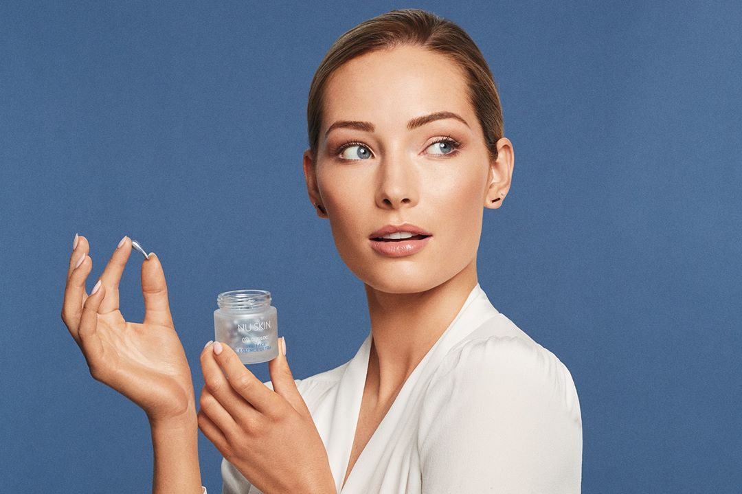 alt="model holding a jar with blue pearls"
